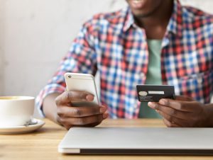 Person holding a cell phone and a payment card