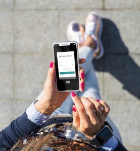 Woman holding phone with Equity Bank app on the phone screen