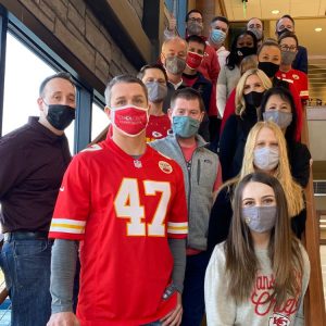 leadership team posing on stairs with masks