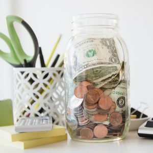 A jar of money and change on a desk