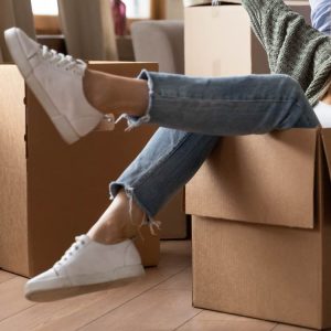 Person sitting in moving box kicking feet up