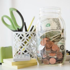 A jar of money and change on a desk