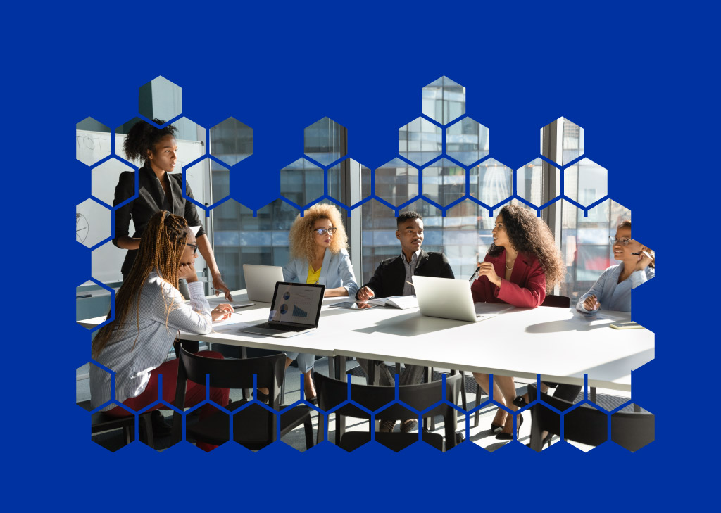 A team of people sits at a conference table during a meeting.