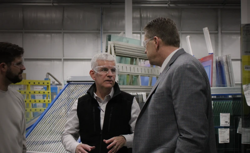 Two people discussing something while standing in a work shop.