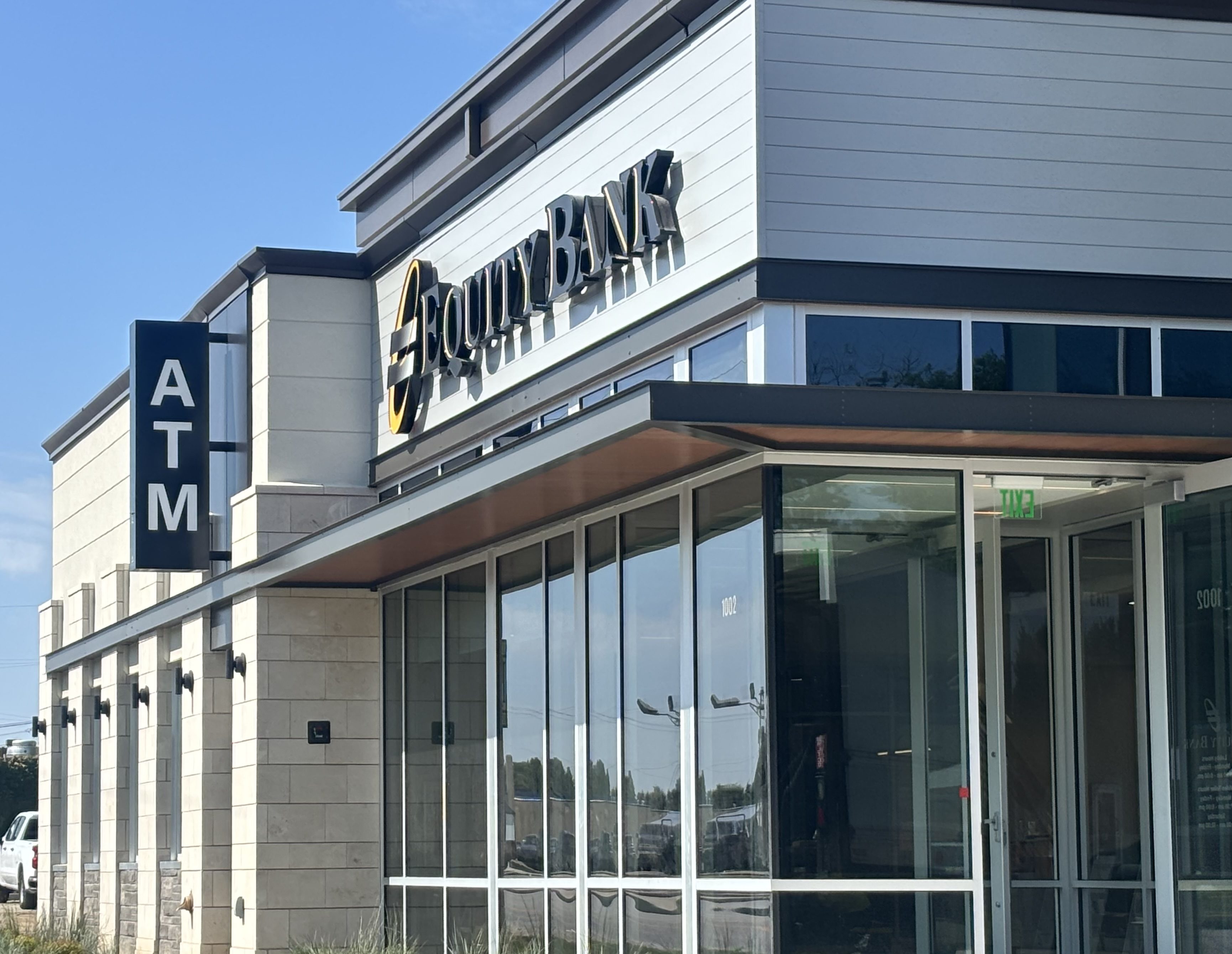Exterior view of a modern bank building with the Country Bank sign and a vertical ATM sign on the left side.