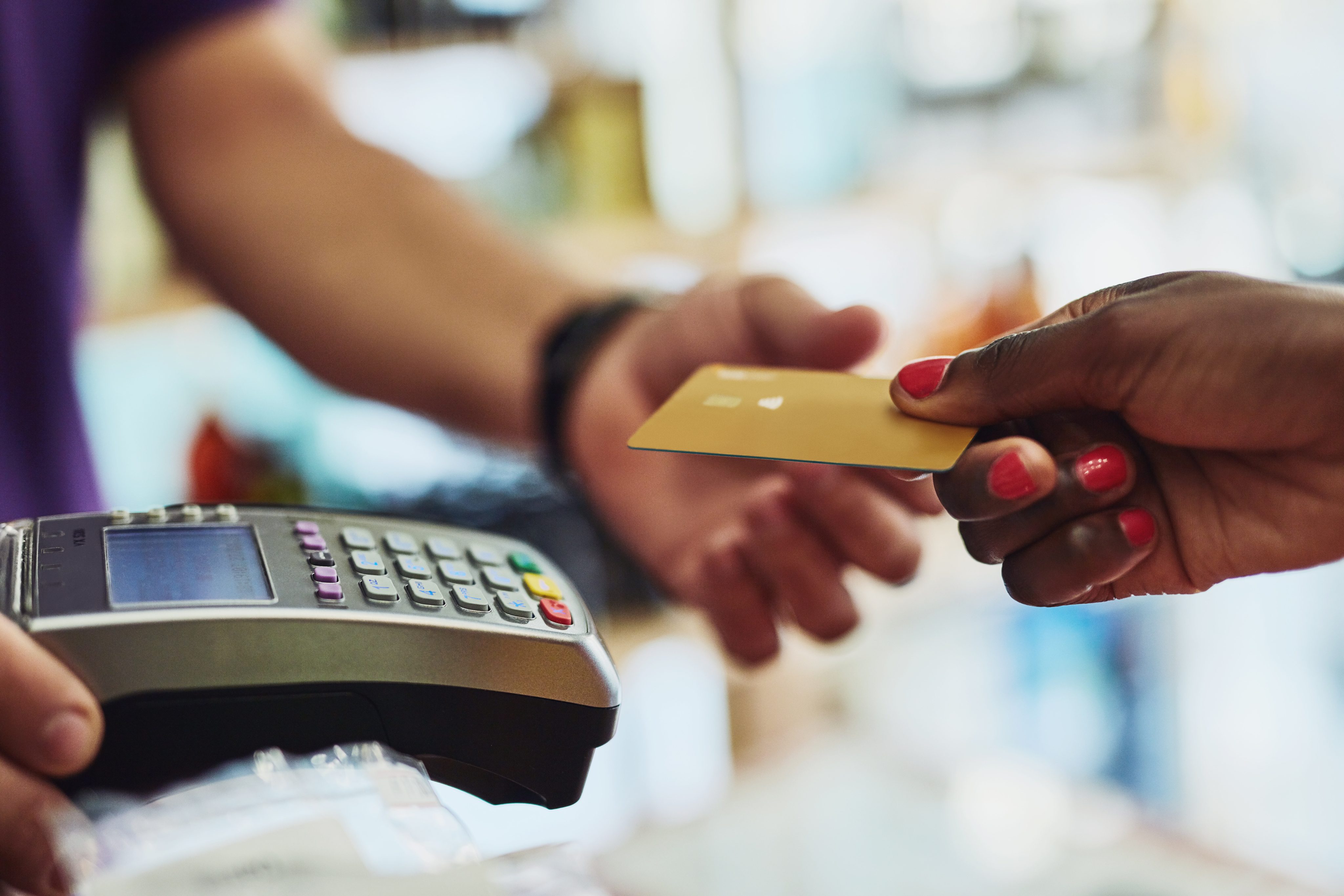 woman using bank debit card to make a purchase at the cashier