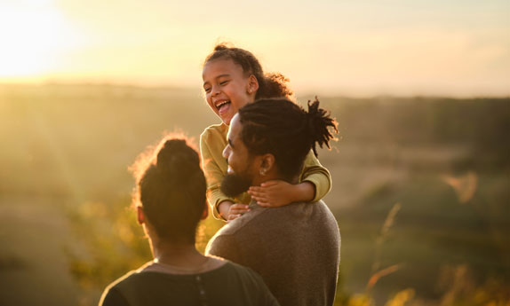 Family walking outdoors during golden hour.